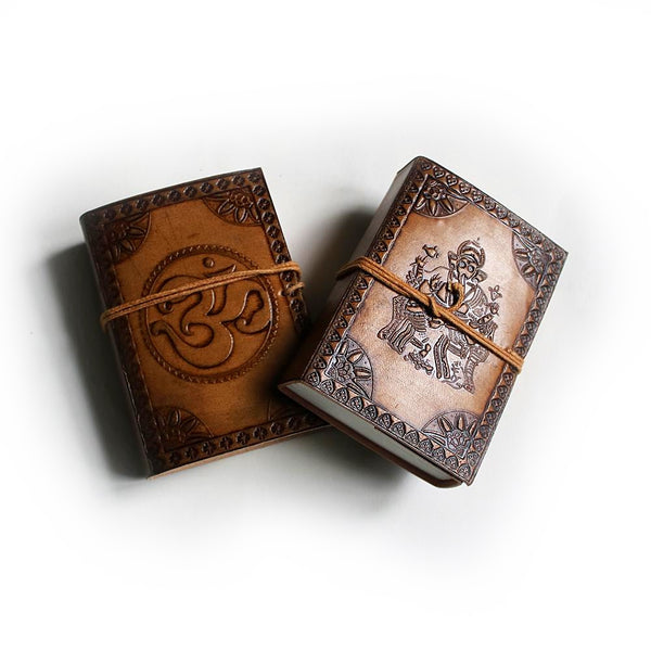 two pocket-sized leather journals featuring Om symbol and Ganesha embossed detail