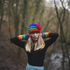 model wears rainbow shell beanie hat with large flower