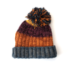 unisex striped bobble hat in purples and oranges